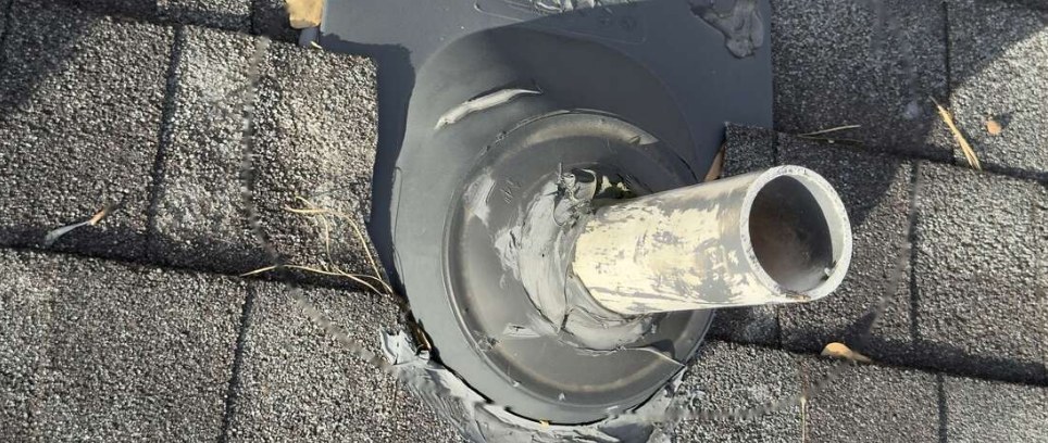 Worn roof vent pipe boot with cracked rubber and patch material around the flashing